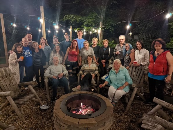 Widow Care members gathered around an outdoor firepit