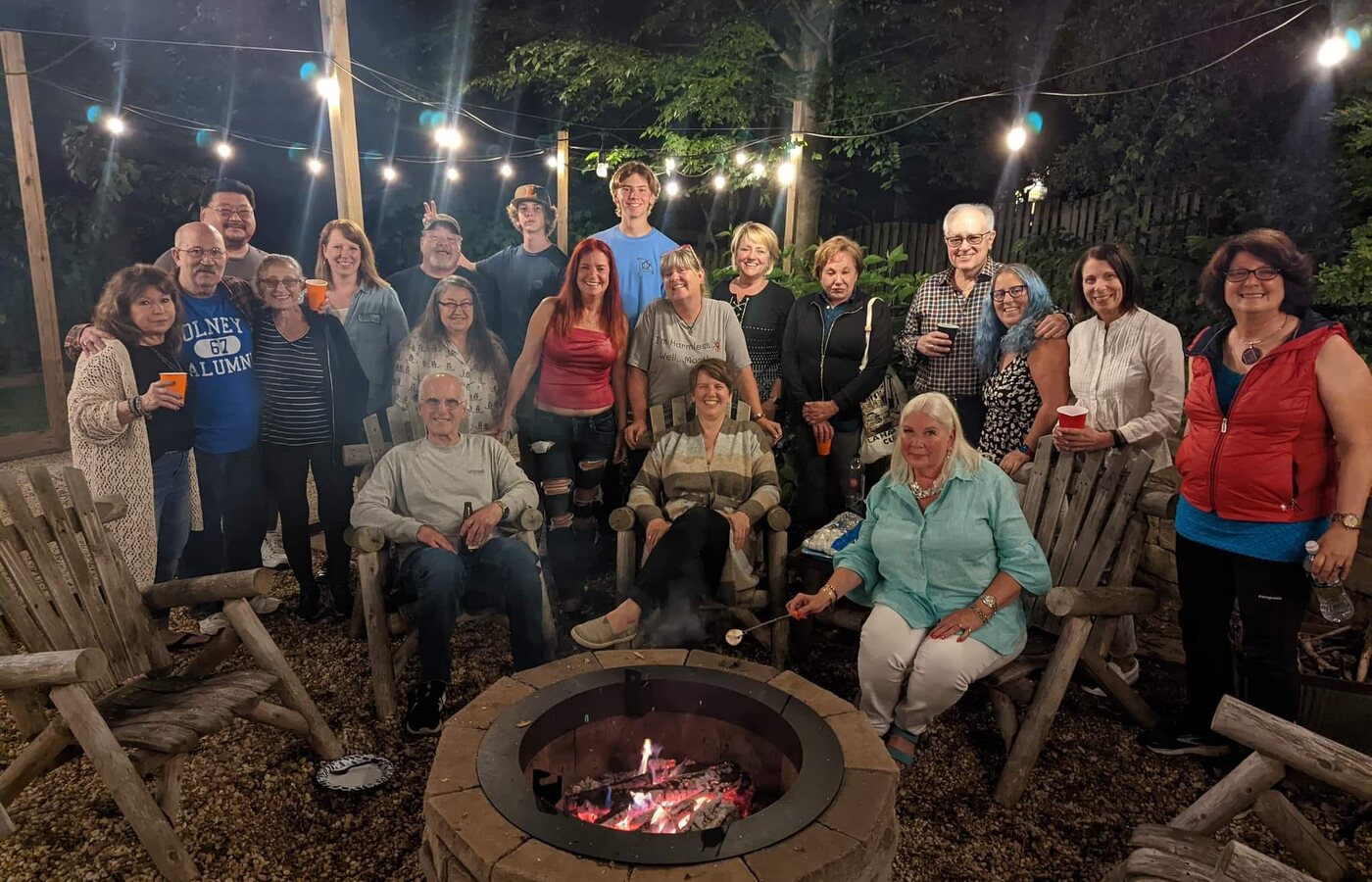 Widow Care members gathered around an outdoor fire pit