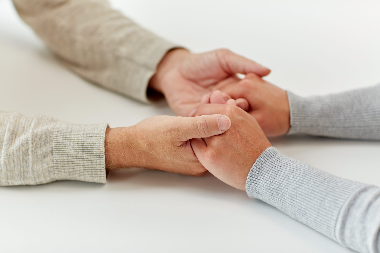 Two hands held in a quiet support moment